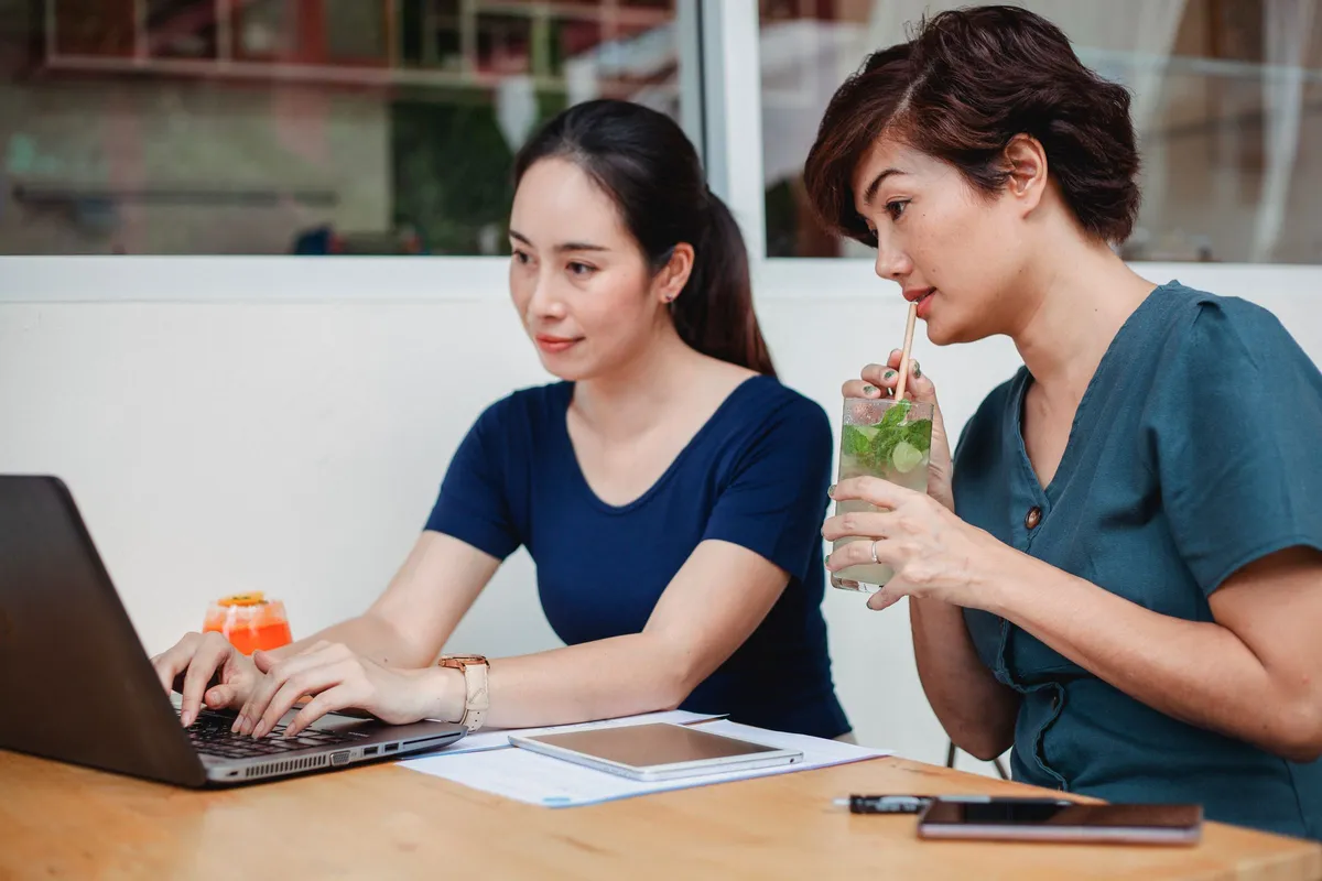 Hai người cùng soạn thư trên máy tính xách tay