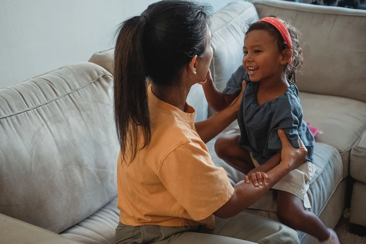 Mẹ trò chuyện cùng con gái trên ghế sofa